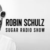 A black and white image of chart hit artist Robin Schulz. He is wearing a shirt and large, white sunglasses. He looks to the right with a neutral expression at the words "Robin Schulz Sugar Radio Show"